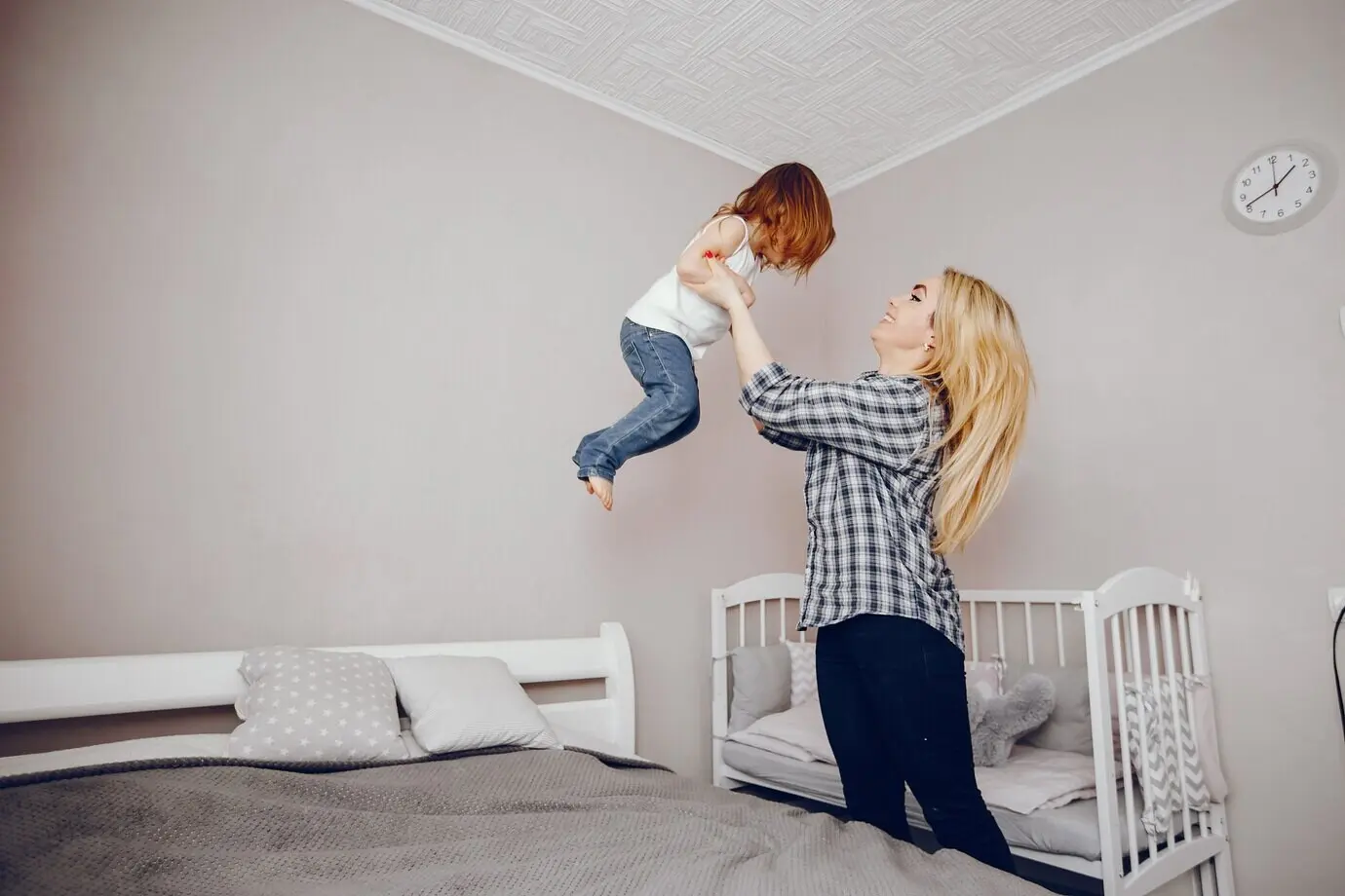 Eine schöne junge Mutter und ihre kleine Tochter spielen zu Hause.